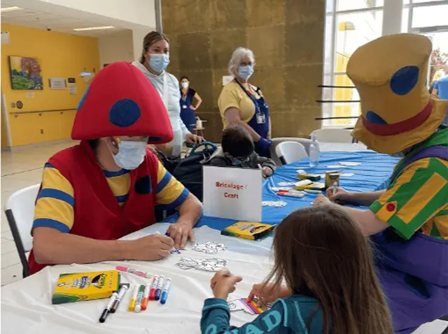 Mascottes de La Ronde animant un atelier de bricolage avec un enfant