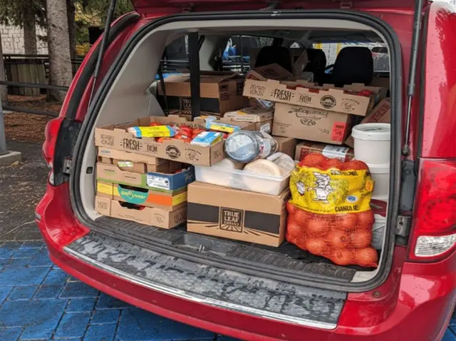 Coffre de voiture rempli de denrées alimentaires pour un don